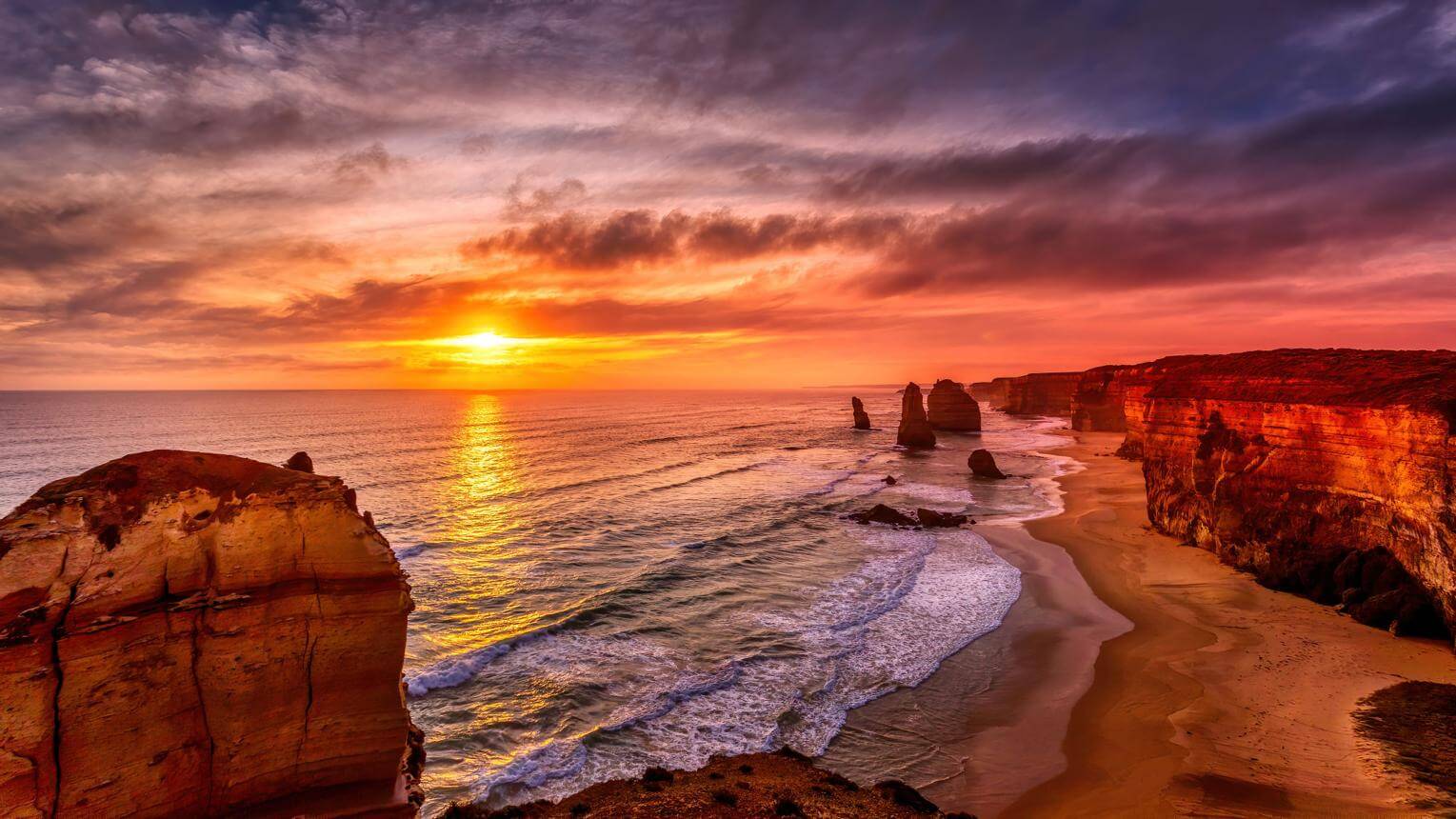 Hoàng hôn tại 12 Apostles trên cung đường Great Ocean Road với các khối đá vôi giữa đại dương Úc