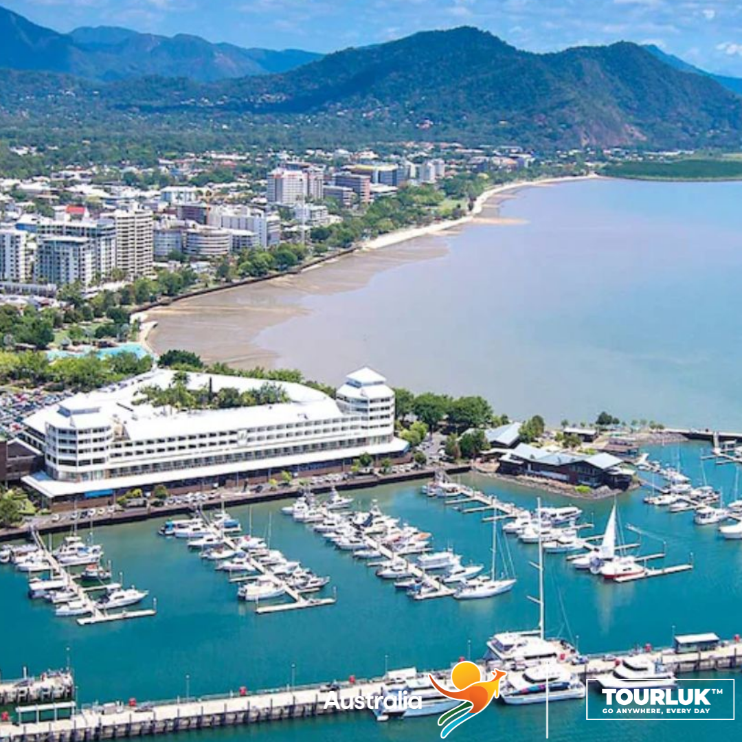 Toàn cảnh Cairns Marina nhìn từ trên cao với bến du thuyền, đường bờ biển và khung cảnh núi non nhiệt đới đặc trưng của Queensland, Úc.