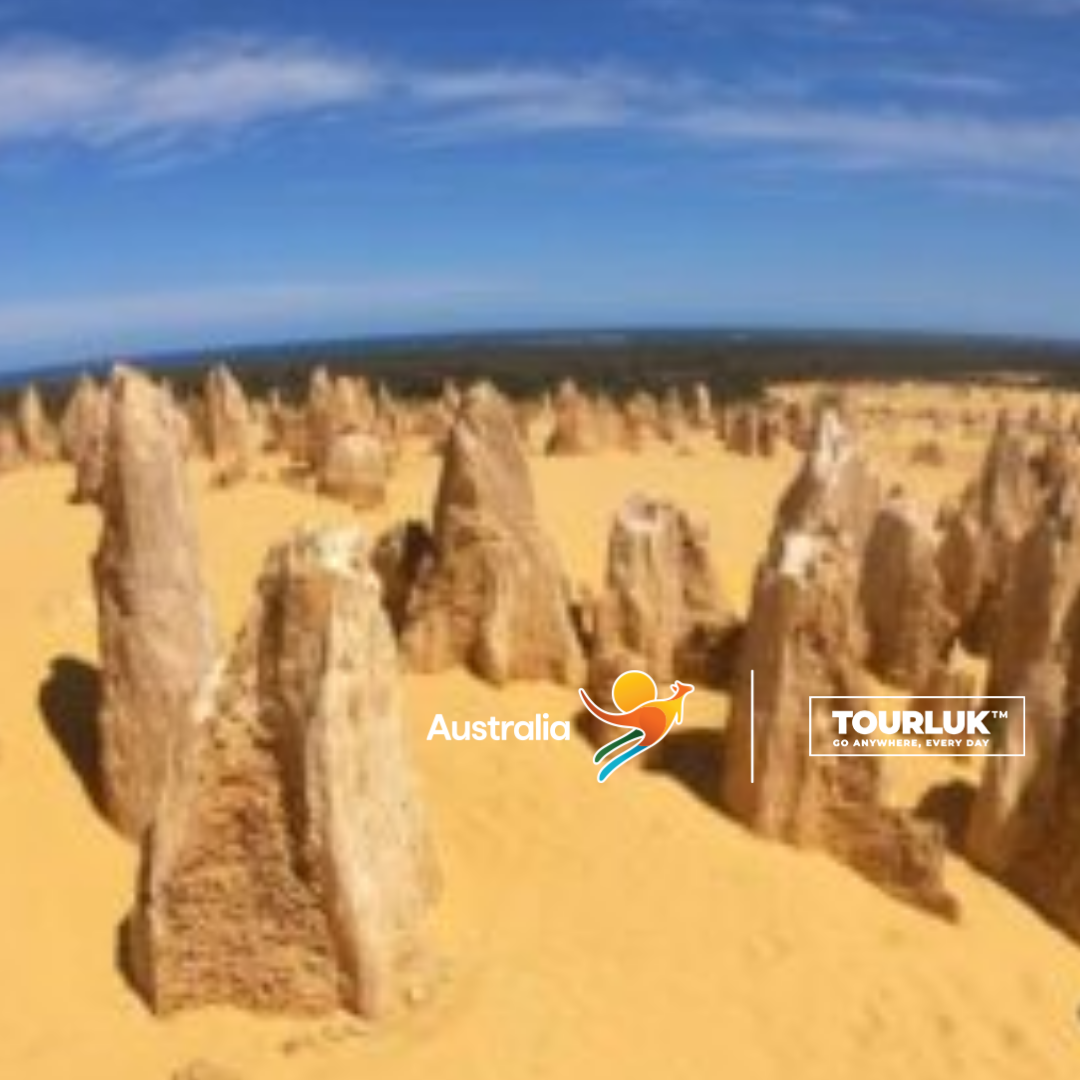 The Pinnacles Desert tại Công viên Quốc gia Nambung, Tây Úc với hàng trăm cột đá vôi nhô lên giữa sa mạc cát vàng dưới bầu trời xanh.