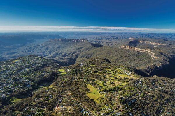 Toàn cảnh Blue Mountains nhìn từ trên cao với núi non trùng điệp, rừng xanh và thị trấn nhỏ xen kẽ.
