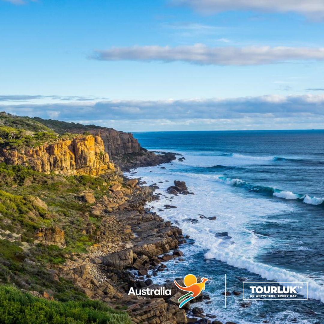 Bờ biển đá hoang sơ tại Tasmania, Úc với những vách đá ven biển và sóng biển xanh trải dài dưới bầu trời trong. 