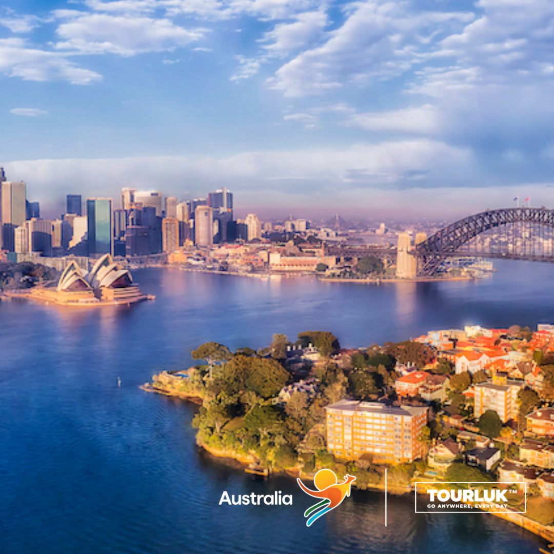 Toàn cảnh Cảng Sydney với Nhà hát Opera Sydney và Cầu cảng Sydney nổi bật bên đường chân trời hiện đại của thành phố.