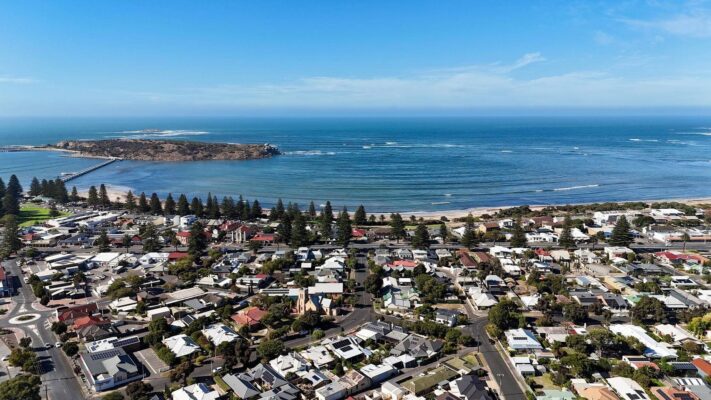 Toàn cảnh thị trấn Victor Harbor của Fleurieu Peninsula nhìn từ trên cao với bãi biển xanh, cầu nối ra đảo Granite Island và khu dân cư ven biển yên bình.