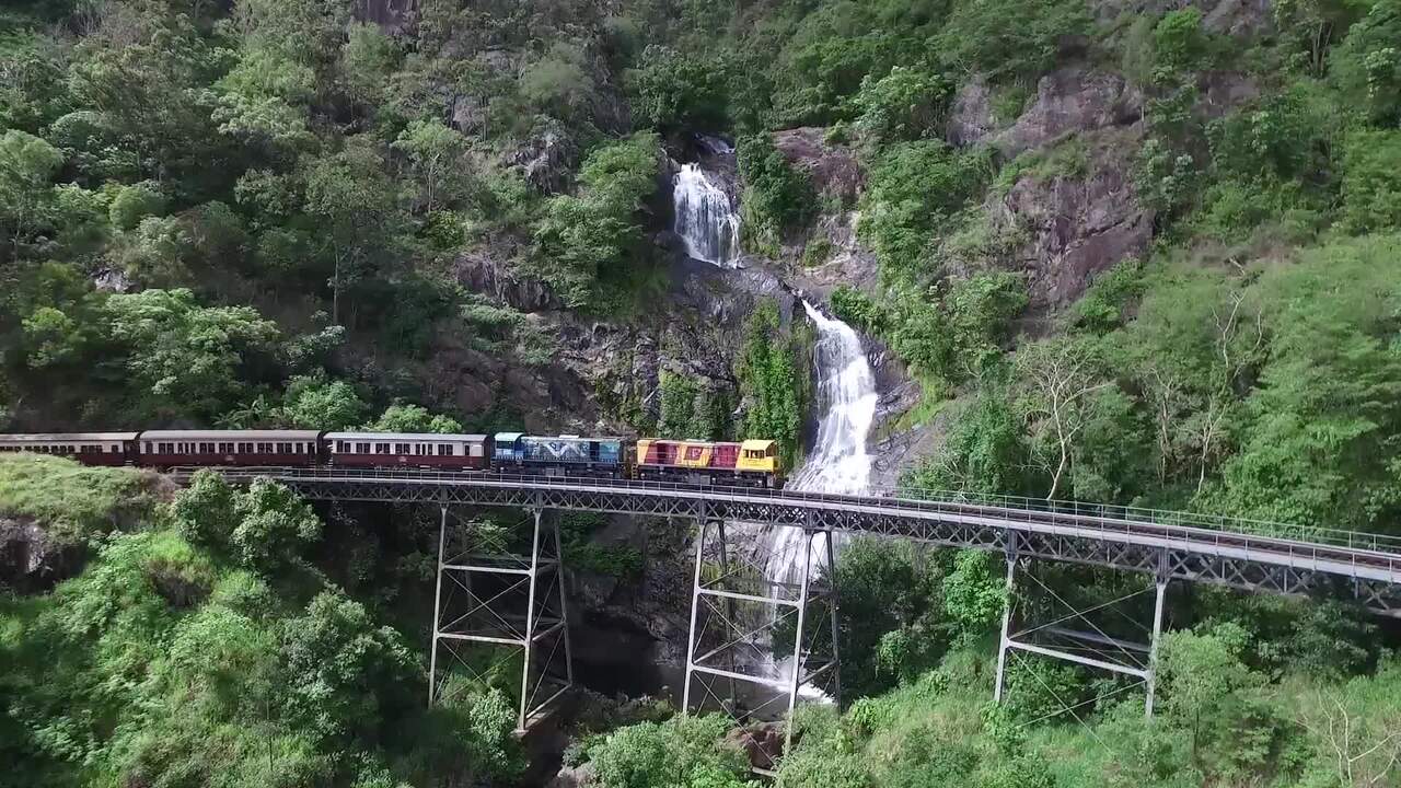 Tàu Kuranda Scenic Railway gần Cairns Úc đi qua thác Barron Falls giữa rừng mưa nhiệt đới hùng vĩ
