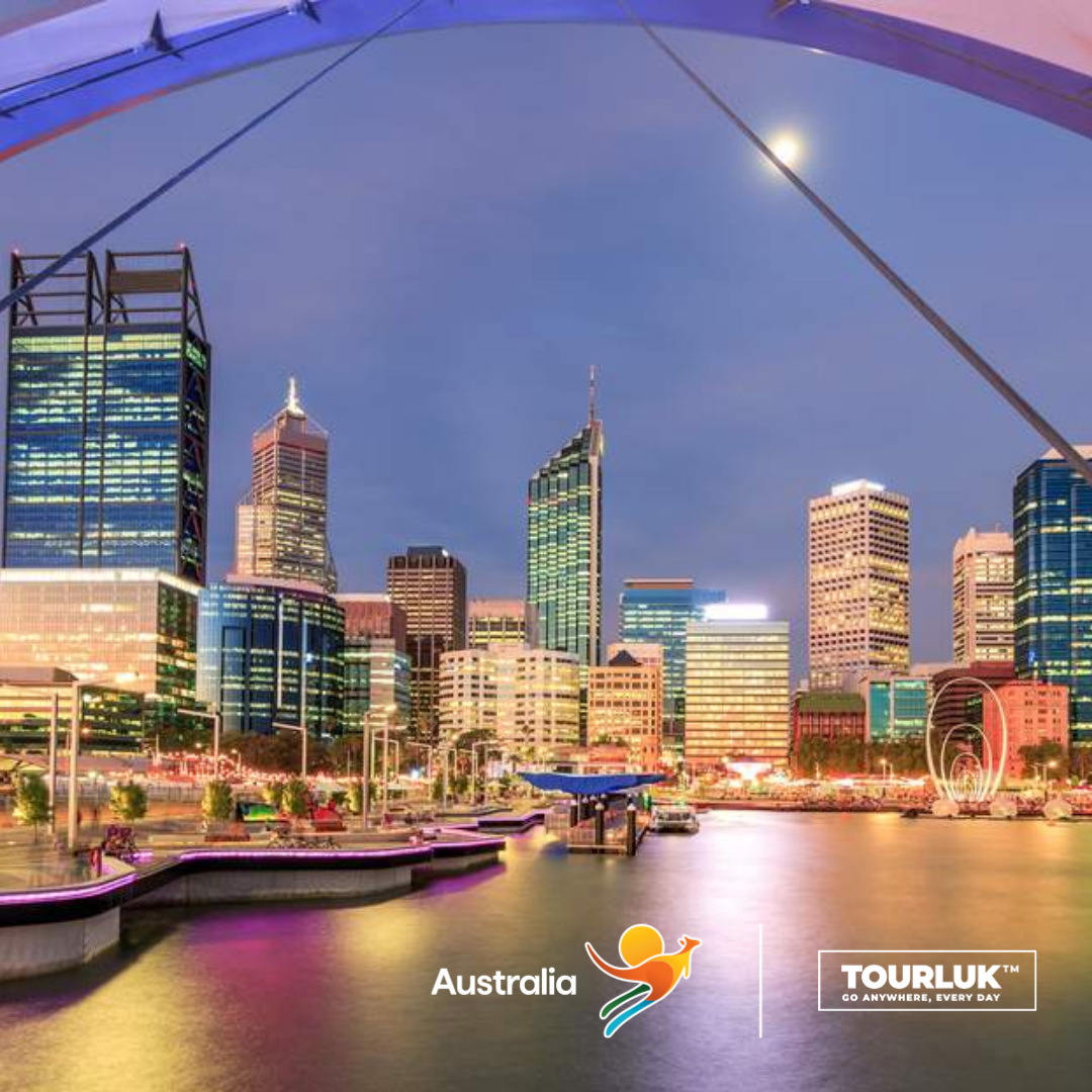 Toàn cảnh khu trung tâm thành phố Perth về đêm với những tòa nhà hiện đại phản chiếu ánh đèn trên mặt nước, tạo nên khung cảnh đô thị sôi động.