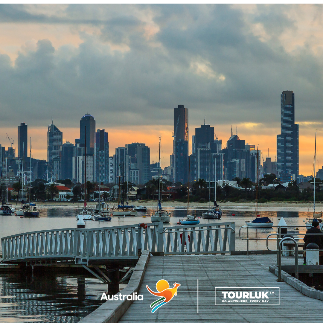 Toàn cảnh thành phố Melbourne lúc hoàng hôn với dòng sông Yarra phản chiếu ánh nắng vàng giữa những tòa nhà hiện đại.