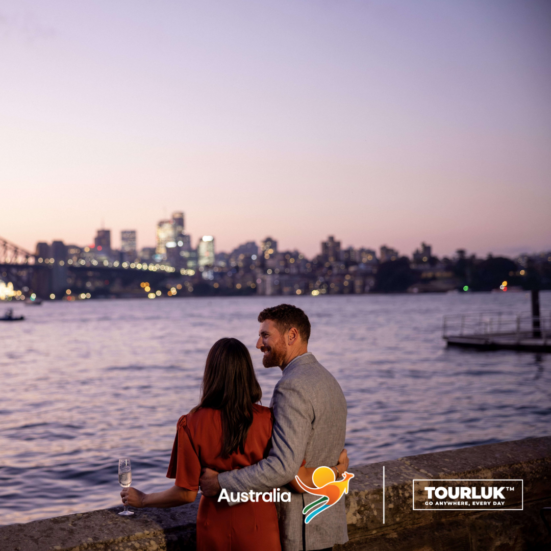 Cặp đôi ngắm hoàng hôn từ ghế Macquaries nhìn Sydney Opera House và Sydney Harbour Bridge tại Sydney, Úc
