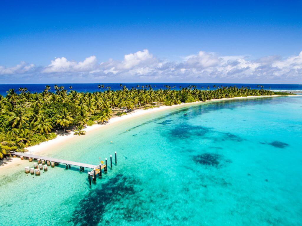 Toàn cảnh Cocos (Keeling) Islands, Australia với bãi cát trắng mịn, hàng dừa xanh trải dài và làn nước biển xanh ngọc trong vắt, tạo nên một thiên đường nhiệt đới hoang sơ lý tưởng cho nghỉ dưỡng và snorkeling.
